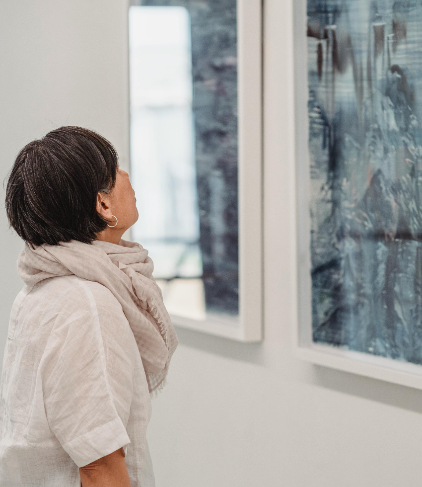 woman staring at a painting in an art museum